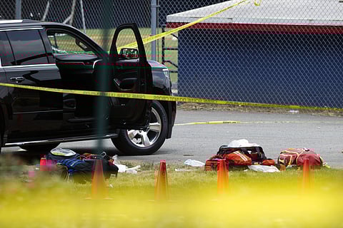 Bags lay on the ground near an automobile with a bullet hole in its windshield in the parking lot of the ball field in Alexandria, Va., Wednesday, June 14, 2017, which was the scene of a multiple shooting involving House Majority Whip Steve Scalise of La.