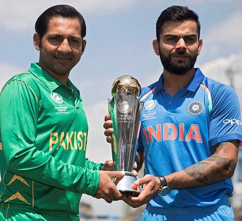 India's captain Virat Kohli right and Pakistan's captain Sarfraz Ahmed pose for a picture with the trophy at the Oval cricket ground in London Saturday June 17 2017.  | AP