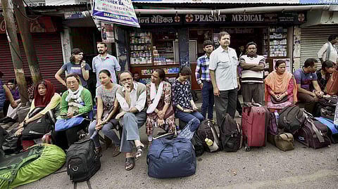 Stranded tourists wait at a bus stand during the indefinite strike called by Gorkha Janamukti Morcha, in Darjeeling on Monday | PTI