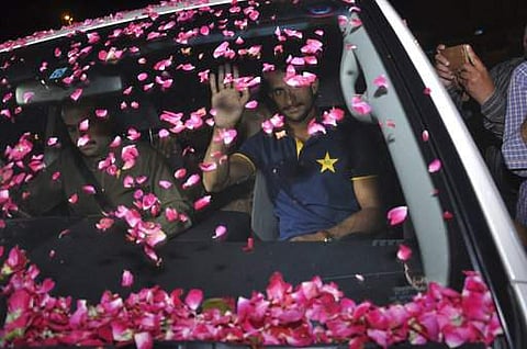 Pakistani cricketer Hasan Ali waves to his fans who showered rose petals on his car at Lahore airport in Pakistan, Tuesday, June 20, 2017. | AP