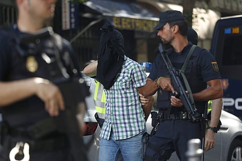 Police lead a suspect from an apartment after a search in Madrid, Spain, Wednesday, June 21, 2017. Spain's Interior Ministry says police have arrested three Moroccans, including a suspected member of the Islamic State group they consider to be a clear thr