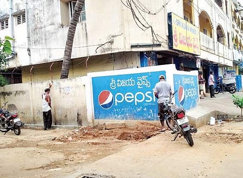 Tipplers relieve themselves near a drain in the vicinity of a wine shop in MVP Colony on Saturday morning. They have made the vacant space near the shop a public toilet. (Photo | Express Photo Service)