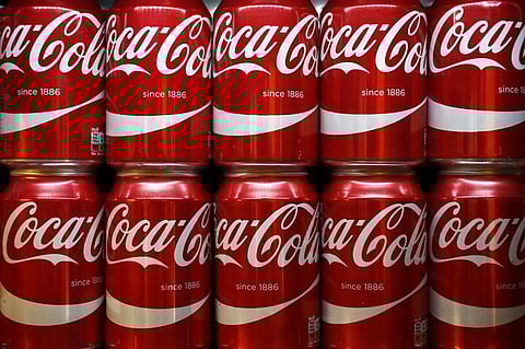 Cans of Coca-Cola sit on a shelf in a store in London, Britain. (File Photo | Reuters)