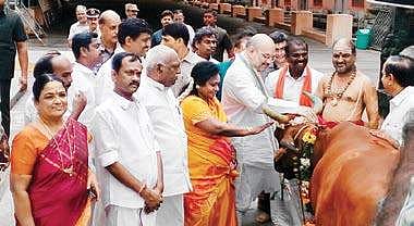 BJP national president petting a cow at the Arunachalaswarar temple in Tiruvannamalai on Tuesday. Minister of State Pon Radhakrishnan, BJP State president Tamilisai Soundararajan, Minister Sevur S Ramachandran and others are also seen | Express