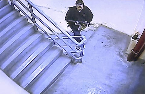 In this image made from security video released by Manila Police and Resorts World Manila on Saturday, June 3, 2017, a gunman walks up a flight of stairs in the Resorts World Manila entertainment and gambling complex in suburban Pasay city, southeast of M