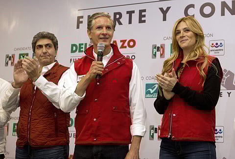 Alfredo Del Mazo, gubernatorial candidate for the ruling Institutional Revolutionary Party, or PRI, stands with his wife Fernanda Castillo, right, and members of his team as he addresses the press to say polls show him leading, at the party's campaign hot