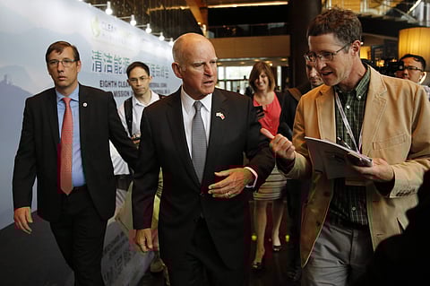 California Gov. Jerry Brown, center, talks with reporters after delivering a speech during the Clean Energy Ministerial International Forum on Electric Vehicle Pilot Cities and Industrial Development, at a hotel in Beijing, Tuesday, June 6, 2017. (AP)