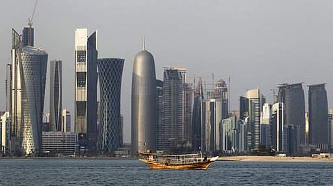 In this Thursday Jan. 6, 2011 file photo, a traditional dhow floats in the Corniche Bay of Doha, Qatar, with tall buildings of the financial district in the background. Qatar, now facing a diplomatic crisis with other Arab nations, is a small country with