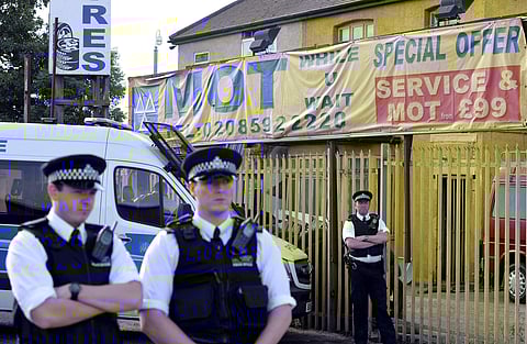 Police stand guard on Ripple Road in east London, where officers have conducted raids after Saturday's deadly terror attack in the capital. | AP