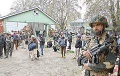 A soldier stands guard as people wait outside a government office near Lal Chowk in Srinagar | Sami ullah