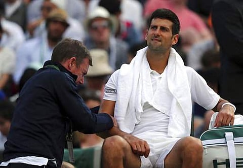 Serbia's Novak Djokovic receives medical treatment during his Men's Singles Match against Czech Republic's Tomas Berdych on day nine of the Wimbledon. | AP