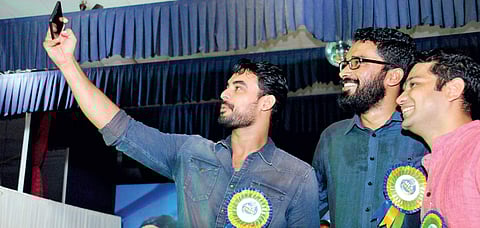Actor Tovino Thomas capturing a selfie along with Employment Exchange director Sriram Venkitaraman and Hibi Eden MLA during the  MLA Award 2017 at St Teresa’s College on Sunday | k Shijith