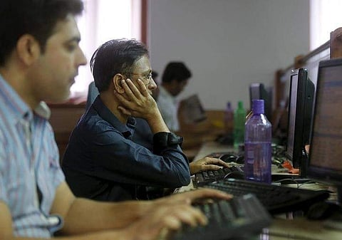Brokers trade at their computer terminals at a stock brokerage firm in Mumbai, India. (File photo | Reuters)