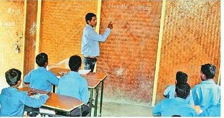 A teacher uses a raised mat as a blackboard to teach his students at Pandewar school in Dantewada district. (EPS)