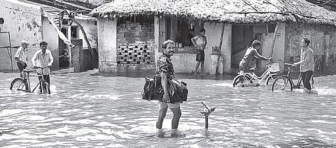 Residents of Sutahat, Dagbar Sahi, wade through an inundated street in Cuttack on Monday   | EXPRESS