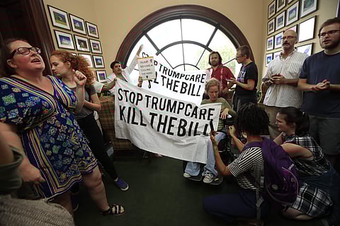 Protesters against the Republican health care bill gather inside the office of Sen. Rob Portman, R-Ohio, on Capitol Hill in Washington, Monday, July 17, 2017. (AP Photo/Manuel Balce Ceneta)