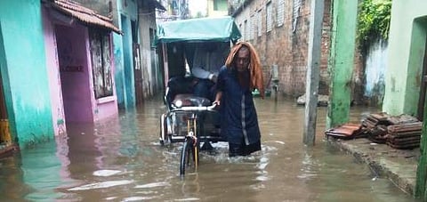 A rickshaw puller crosses an inundated road at Makarbag Sahi | Express