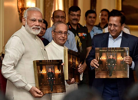 Prime Minister Narendra Modi releasing the photo book titled President Pranab Mukherjee - A Statesman and presenting first copy to the President Pranab Mukherjee at Rashtrapati Bhawan in New Delhi on Sunday. (PTI)