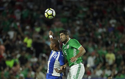 Honduras' Ovidio Lanza, left, goes for a header with Mexico's Jair Pereira during a CONCACAF Gold Cup quarterfinal soccer match. | AP