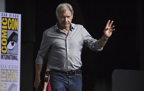 Harrison Ford waves to the audience as he walks on stage at the Warner Bros. 'Blade Runner' panel on day three of Comic-Con International on Saturday, July 22, 2017, in San Diego. (Photo by Richard Shotwell/Invision/AP)