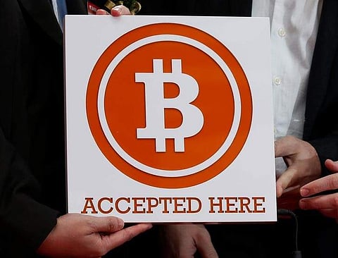 A bitcoin sign is held in Hong Kong February 28, 2014. | Reuters