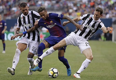 Barcelona's Neymar, center, battles against Juventus' Stefano Sturaro, left, and Stephan Lichtsteiner during the first half of an International Champions Cup soccer match. | AP