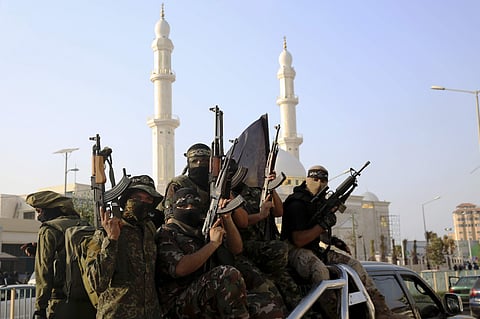 Masked militants from the al-Nasser Brigades, an armed wing of the Popular Resistance Committees (PRC), march with their weapons on a vehicle during a parade against Israeli arrangements in a contested Jerusalem shrine, along the streets of Gaza City, Tue