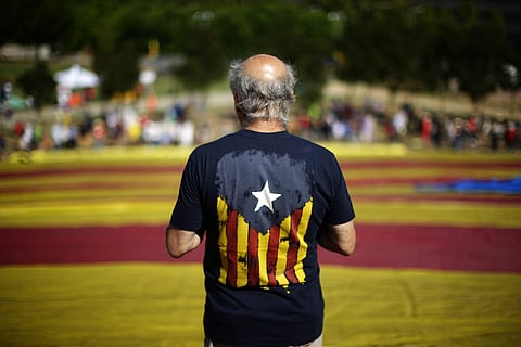 A man participates displaying a giant 'estelada' or pro-independence flag for the independence of Catalonia in Sant Cugat del Valles, Spain (AP)