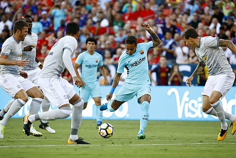 Barcelona's Neymar, center, kicks through Manchester United defenders during the first half of an International Champions Cup soccer match. | AP