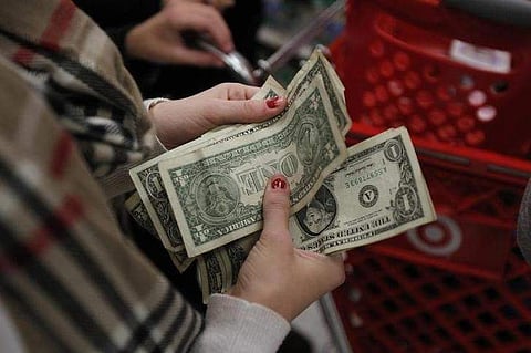 A customer counts her money while waiting in line to check out at a Target store on the shopping day dubbed 'Black Friday' in Torrington, Connecticut. (File Photo | Reuters)