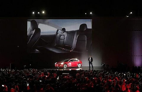Tesla Chief Executive Elon Musk introduces one of the first Model 3 cars off the Fremont factory's production line during an event at the company's facilities in Fremont. | Reuters