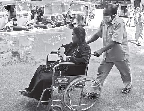 A woman suffering from fever being taken in a wheelchair from the casualty wing to the fever ward for admission at the General Hospital in Thiruvananthapuram on Thursday | B P Deepu