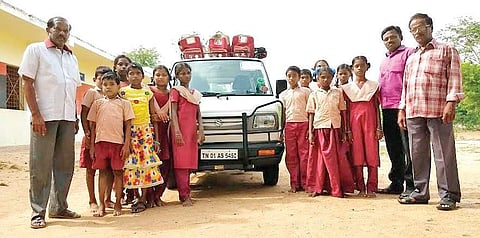 Karunamurthy and students with the van he gifted his school | express
