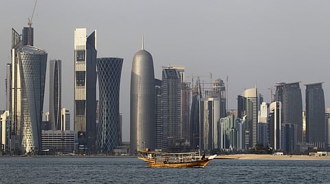 A traditional dhow floats in the Corniche Bay of Doha, Qatar, with tall buildings of the financial district in the background. (File photo | AP)