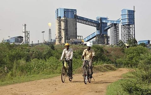 Men ride their bicycles in front of the Bhushan Steel plant in Odisha. (File photo | Reuters)