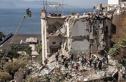 Firefighters search the rubble after two floors collapsed in a small four-storey building in Torre Annunziata, in a town near the Italian city of Naples, on July 7. (Photo | AFP)