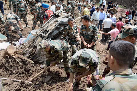 Rescue and relief works being carried out on Sunday after two buses and some other vehicles were swept away by a massive landslide at Kotrupi in Mandi district on Saturday night. | PTI