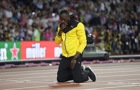 Jamaica's Usain Bolt kneels down during a lap of honor at the end of the World Athletics Championships in London Sunday, Aug. 13, 2017. | AP