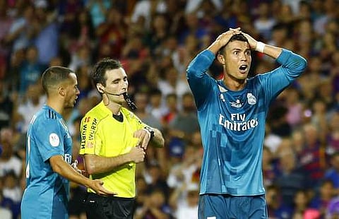 Real Madrid's Cristiano Ronaldo, right, reacts after Referee Ricardo de Burgos shows a yellow card during the Spanish Supercup, first leg, soccer match between FC Barcelona and Real Madrid. | AP