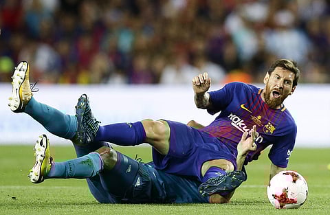 FC Barcelona's Lionel Messi is tackled during the Spanish Supercup, first leg, soccer match between FC Barcelona and Real Madrid at the Camp Nou stadium in Barcelona. | AP