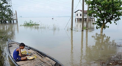 A child having his meal on a boat at a flood affected village in Morigaon district of Assam on Wednesday.