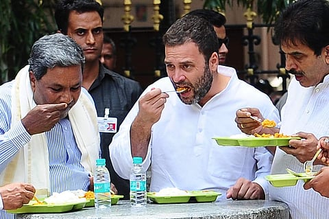 Congress National Vice President Rahul Gandhi and Karntaka Chief Minister Siddaramaih and Karnataka Incharge Venugopal  having food after inaugurating the Indhira Canteen at Kanakana Palya in Bengaluru on Wednesday. (Nagesh Polali | EPS)