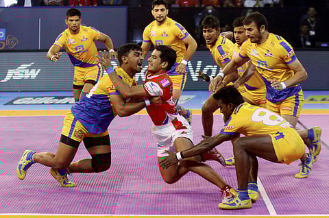 Players of Tamil Talaivas in Yellow catch a player of Haryana Steelers in Red during their pro Kabaddi league in Ahmedabad on Wednesday. | PTI