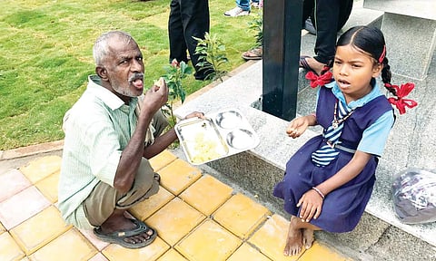 An old man shares breakfast with a young girl at a newly inaugurated Indira Canteen in Radhakrishna Temple Ward, Hebbal. The photograph was taken by BBMP commissioner N Manjunath Prasad on his cell-phone