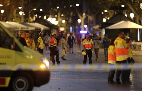 Emergency workers stand on a street  in Barcelona, blocked  after the first terrorist attack happened on August 17.(Photo | AP)