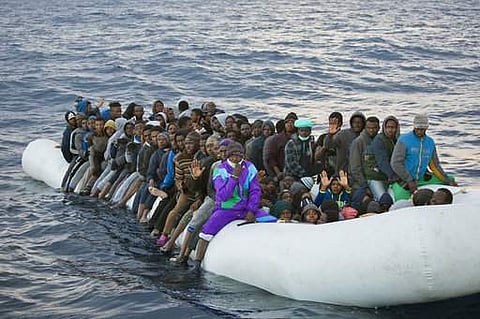Migrants and refugees wait to be helped by members of the Spanish NGO Proactiva Open Arms, as they crowd aboard a rubber boat sailing out of control in the Mediterranean Sea. (AP)