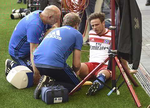 Hamburg's Nicolai Mueller is treated during the German Bundesliga soccer match between Hamburger SV and FC Augsburg in Hamburg. | AP