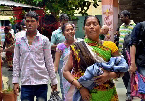 Relatives carry a child at the Baba Raghav Das Medical College Hospital where over 70 children have died. | PTI