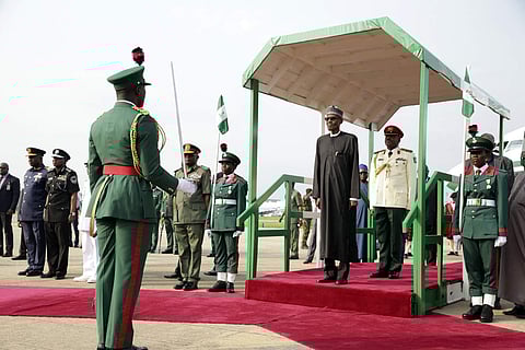 Nigeria President Muhammadu Buhari is greeted by a guard of honour, upon his arrival at the Nnamdi Azikiwe airport in Abuja (AP)