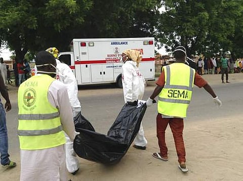 Rescue workers remove the body of a victim after a suicide bomb attack at a camp for people displaced by Islamist extremist in Maiduguri, Nigeria.|AP